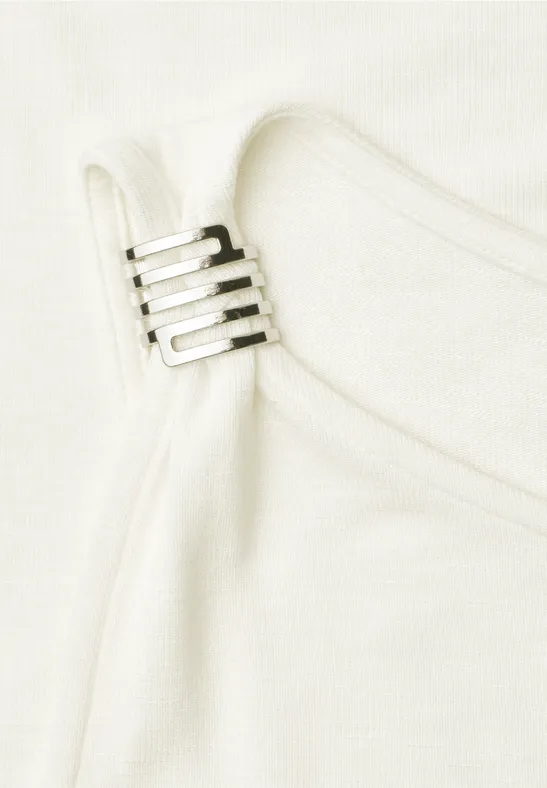 Witte stofband met verstelbare metalen ring, detail van een kledingstuk