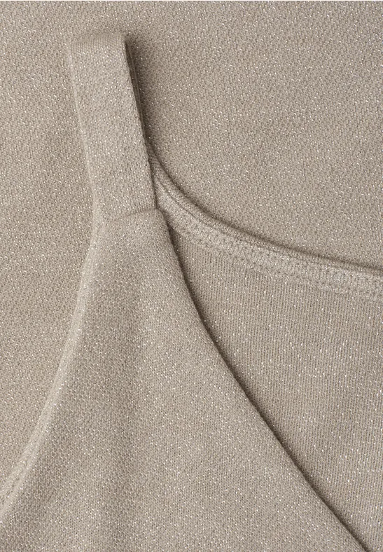 Nahaufnahme eines beigen, schimmernden Spaghettiträgershirts