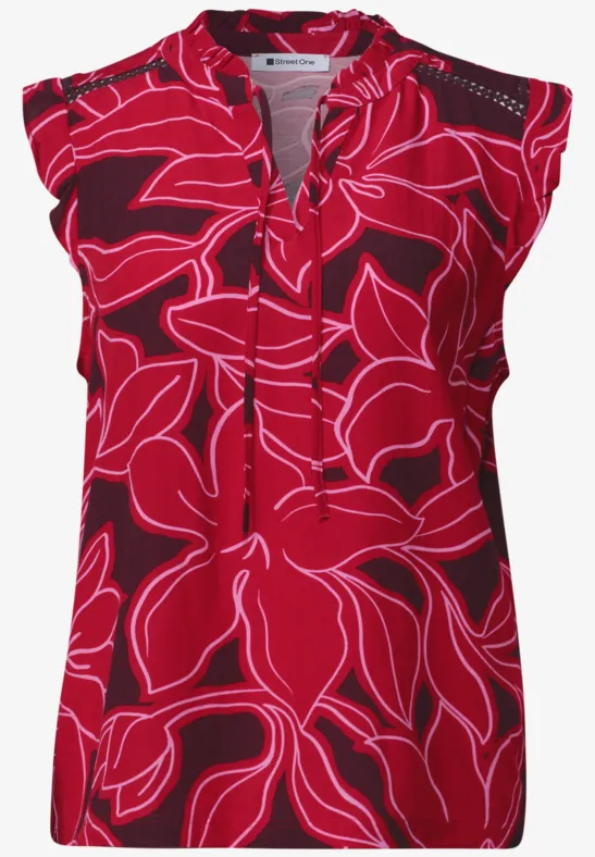 Rode mouwloze top met felroze bloemmotief, V-hals en licht geplooide schouders.