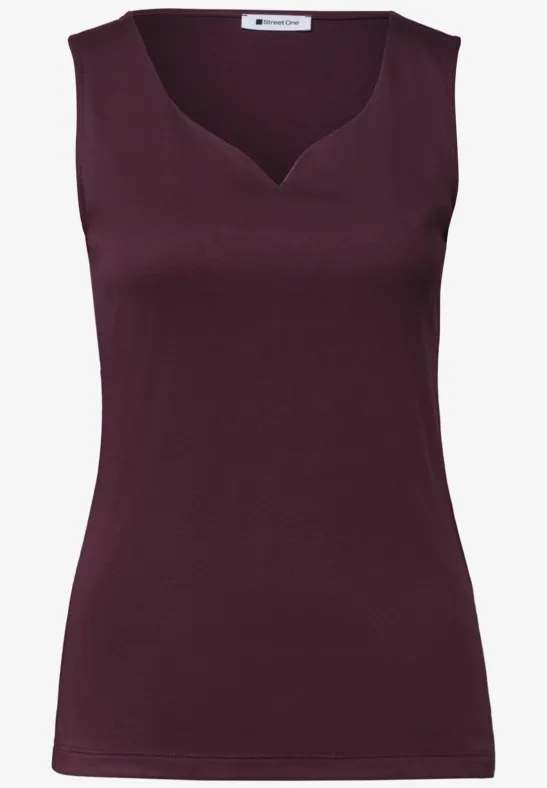 Top sans manches bordeaux, cintré, avec un décolleté légèrement asymétrique.