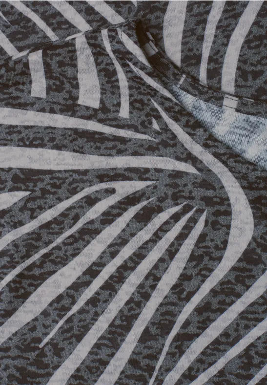 Close-up van een stof met een abstract zebradessin in grijs- en wittinten.