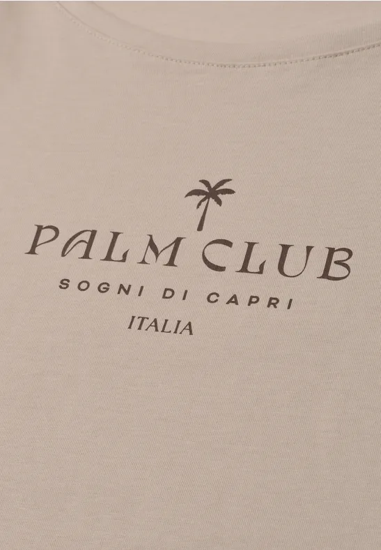 Beige T-shirtopdruk met 'PALM CLUB', palmboom-pictogram en tekst 'SOGNI DI CAPRI ITALIA'.