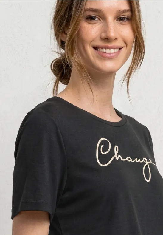 Portret van een vrouw met een zwart t-shirt voor een lichte achtergrond.