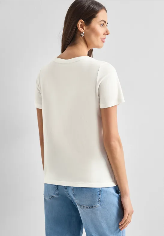 Frau von hinten in weißem T-Shirt und blauer Jeans.