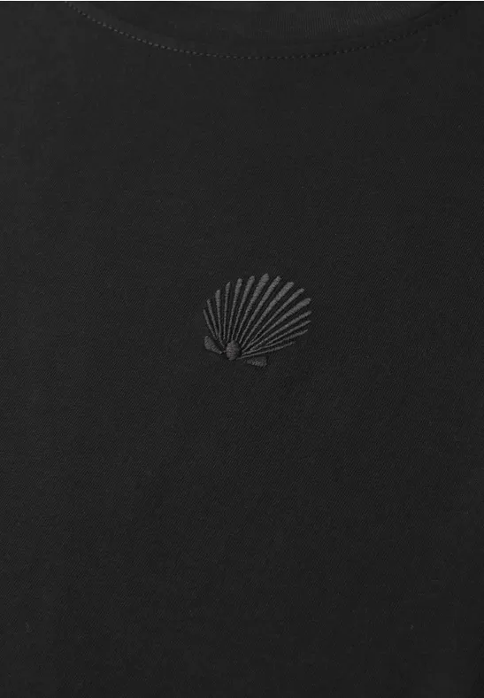 Schwarzes T-Shirt mit dezentem Muschelmotiv auf Brusthöhe.
