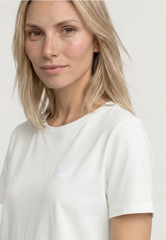 Vrouw met een wit T-shirt voor een neutrale achtergrond.