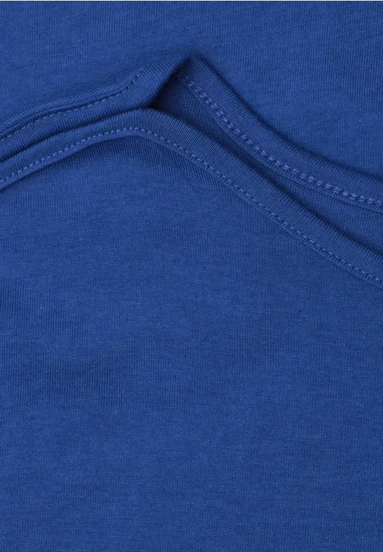 Close-up van een gebogen naad in blauw textiel.