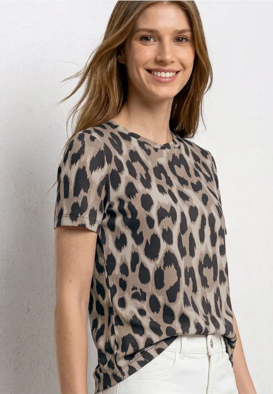 Vrouw in een kort mouw t-shirt met luipaardprint en een witte high-waist broek.