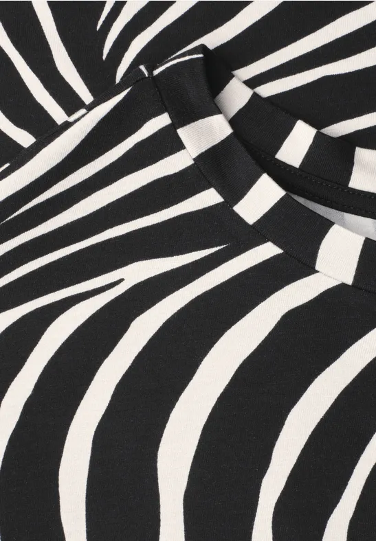Motif zébré en noir et blanc sur un haut, avec des rayures contrastées.