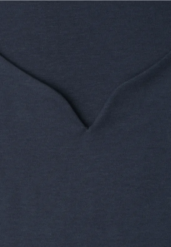 Detailaufnahme eines dunkelblauen Stoffes mit V-förmiger Naht.