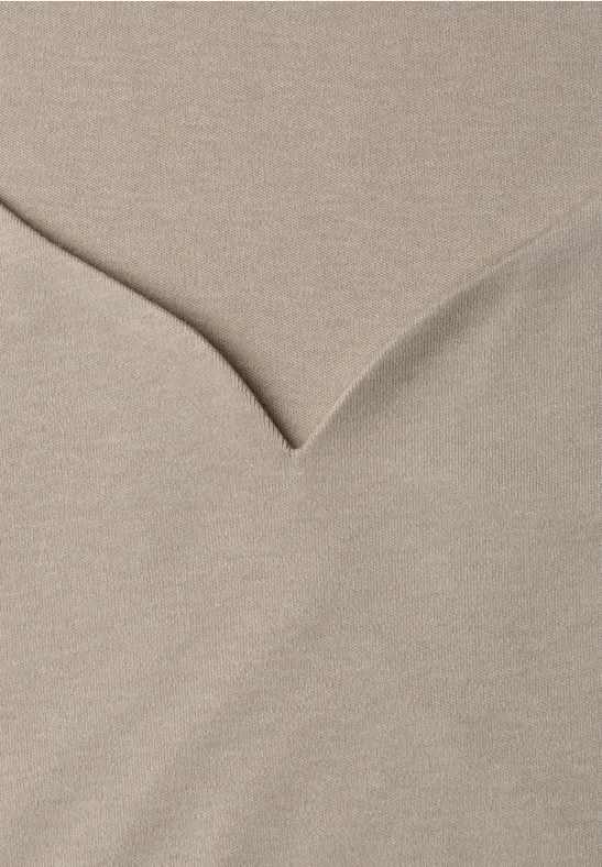 Beiger Pullover mit V-Ausschnitt aus weichem Strickstoff.