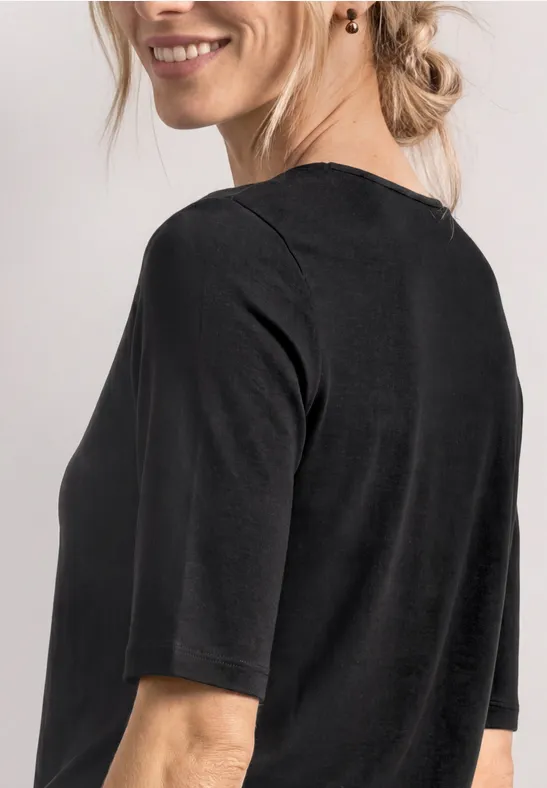Vrouw van achteren in een zwart shirt met halflange mouwen, losse knot en subtiele oorbel.
