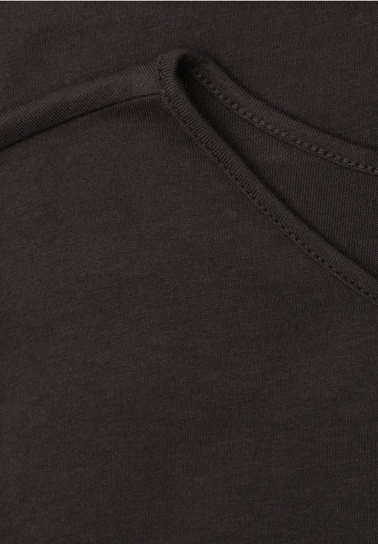 Close-up van een zwart kledingstuk met zichtbare naad en een zakopening.
