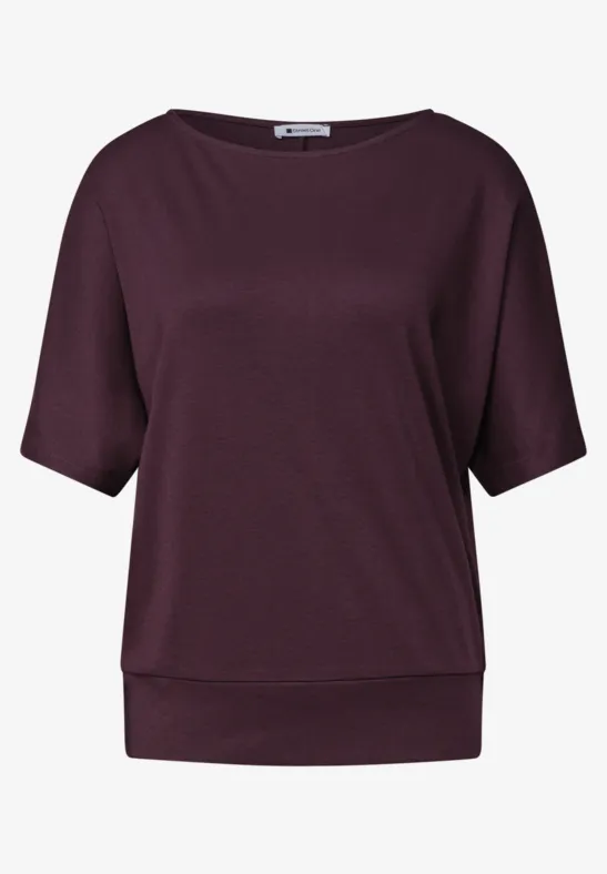 Ein schlichtes, tailliertes Damen-Shirt in dunklem Lila mit halblangen Ärmeln und breitem Bund.
