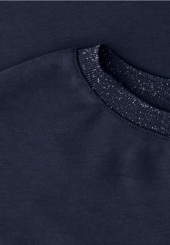 Gros plan sur un sweat bleu marine à col côtelé pailleté