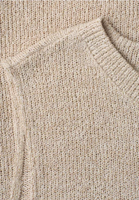 Nahaufnahme eines beigen Strickpullovers aus grobem Garn