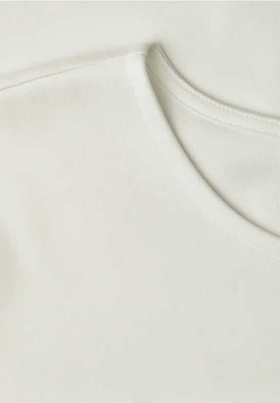 Close-up van een effen witte T-shirt halslijn.