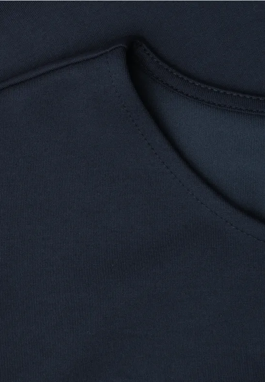 Close-up van de donkerblauwe ronde hals met nette stiksels en gladde stof.