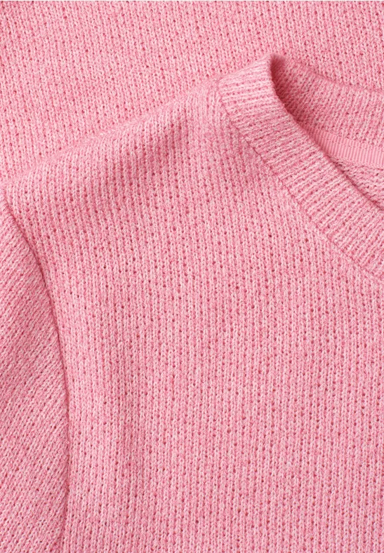Nahaufnahme eines rosa Strickpullovers mit Rundhalsausschnitt.