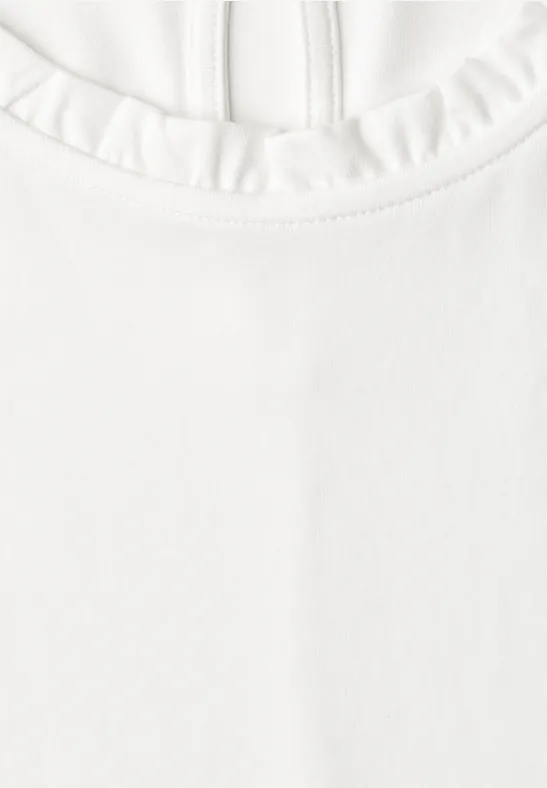 Witte top met ronde hals en ruchesrand.