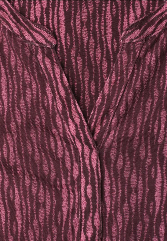 Dunkelrotes Oberteil mit pinkfarbenen, unregelmäßigen Wellenstreifen und V-Ausschnitt.