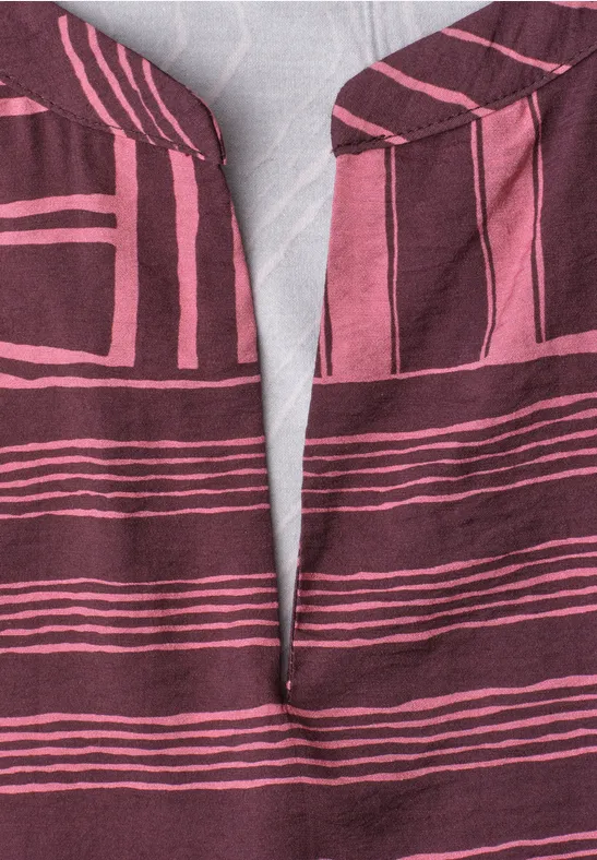 Gros plan sur un tissu bordeaux à rayures roses et encolure en V