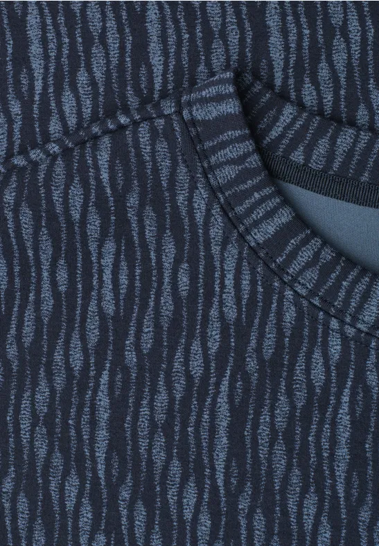 Close-up van donkerblauw textiel met lichtblauwe, golvende patronen en een zak.