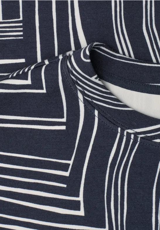 Close-up van donkerblauw stof met witte, geometrische lijnpatronen en zichtbare halslijn.