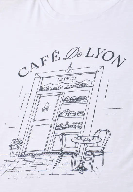 Façade de café 'Café De Lyon' stylisée, avec table et chaises en terrasse.
