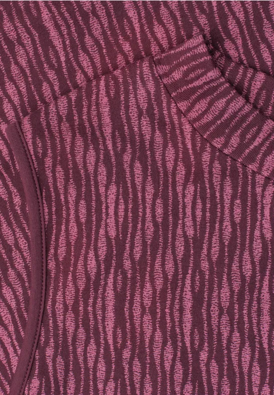 Gros plan sur un tissu violet et rose à motif ondulé, détail de poche sur un vêtement