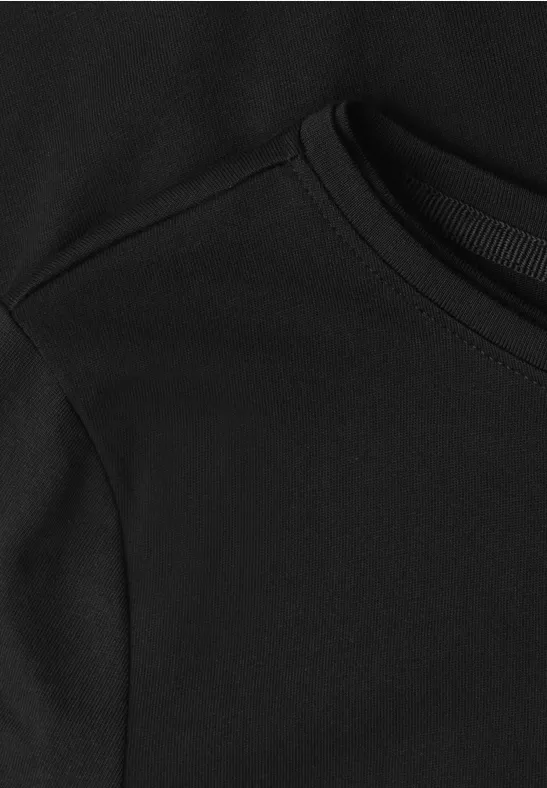 Nahaufnahme eines schwarzen Sweatshirts oder Hoodies mit sichtbarer Naht und Rundhalsausschnitt.