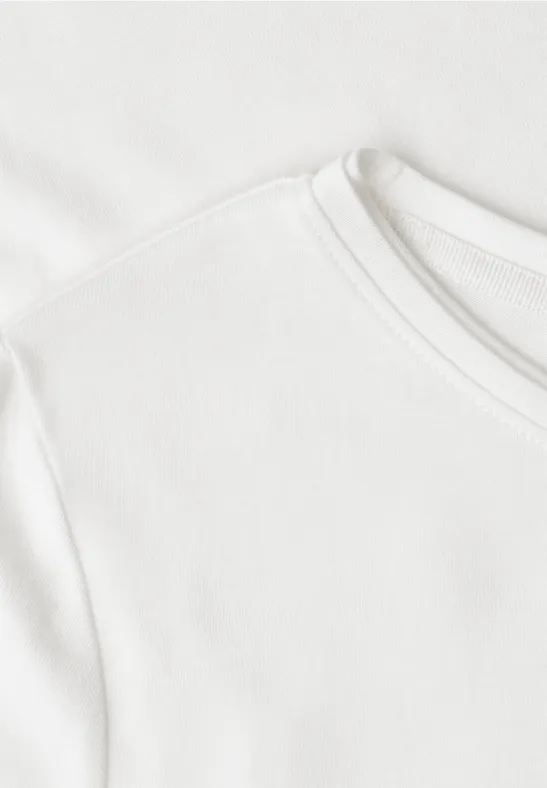 Nahaufnahme eines weißen T-Shirts mit Rundhalsausschnitt und feiner Baumwollstruktur.