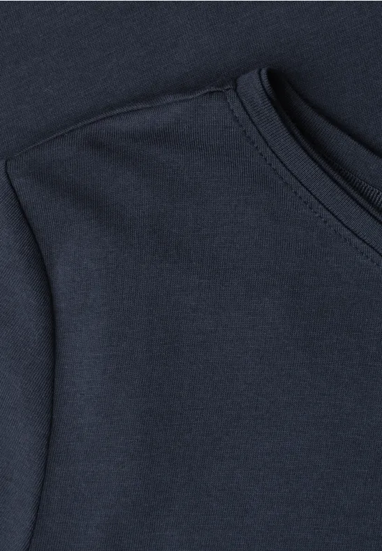 Nahaufnahme eines dunkelblauen T-Shirts mit sichtbarer Schulterpartie und Rundhalsausschnitt.