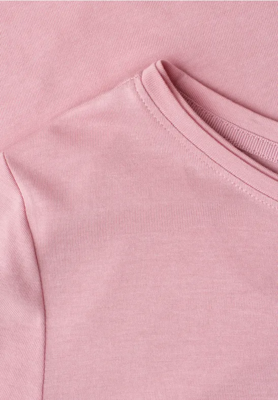 Nahaufnahme eines rosa T-Shirts aus weichem Stoff mit Rundhalsausschnitt.