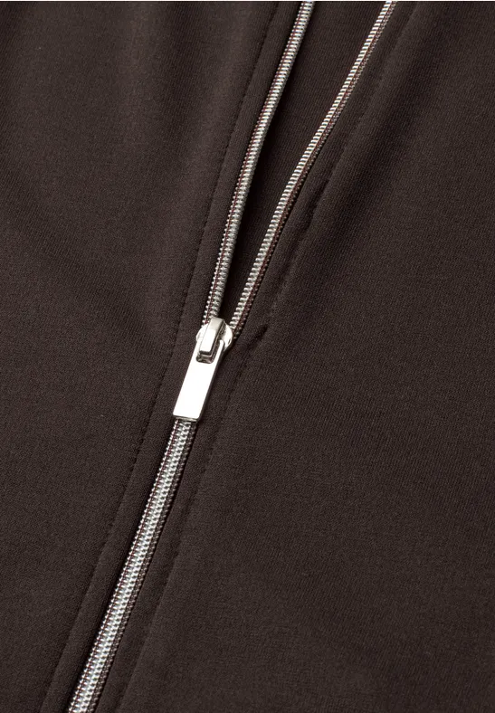 Close-up van een zilverkleurige rits op donkere stof.
