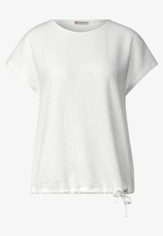 Weißes Kurzarmshirt mit Rautenmuster, locker geschnitten und mit Kordelzug am Saum.