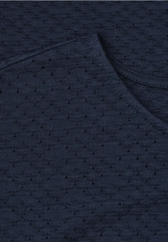 Nahaufnahme eines dunkelblauen Strickstoffs mit feinem Lochmuster und abgerundetem Saum.