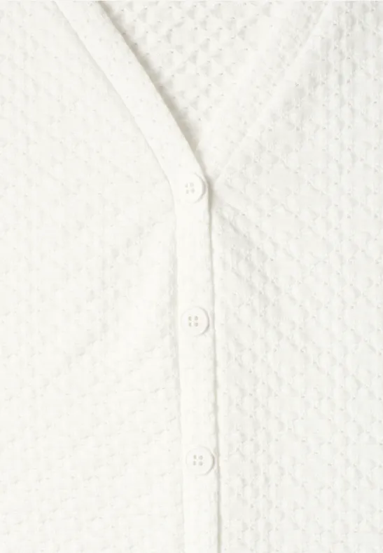 Weißer Cardigan mit Wabenmuster und Knopfleiste.