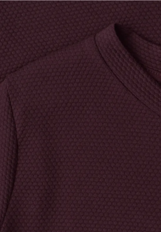 Dunkelroter, strukturierter Pullover mit feinem Wabenmuster.