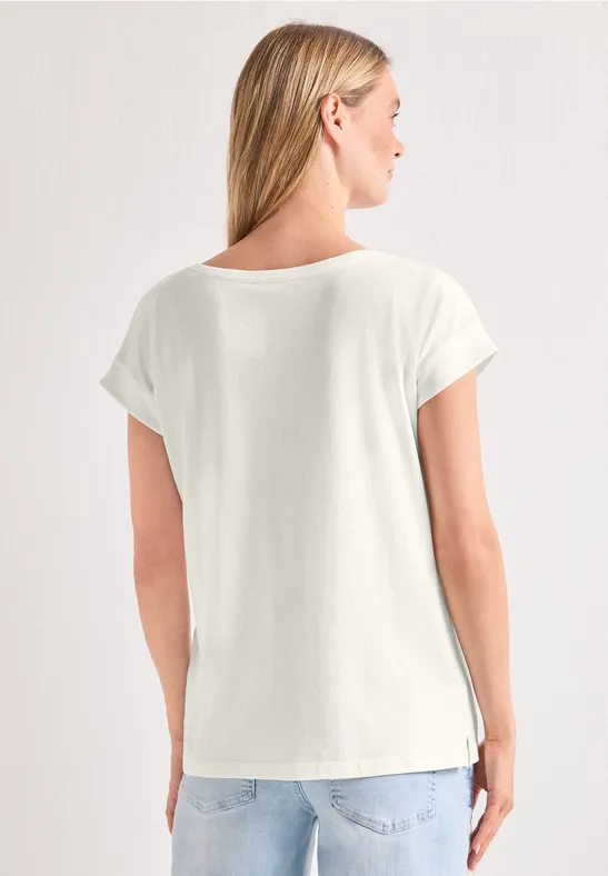 Vrouw van achteren in wit t-shirt met korte mouwen en een blauwe spijkerbroek.