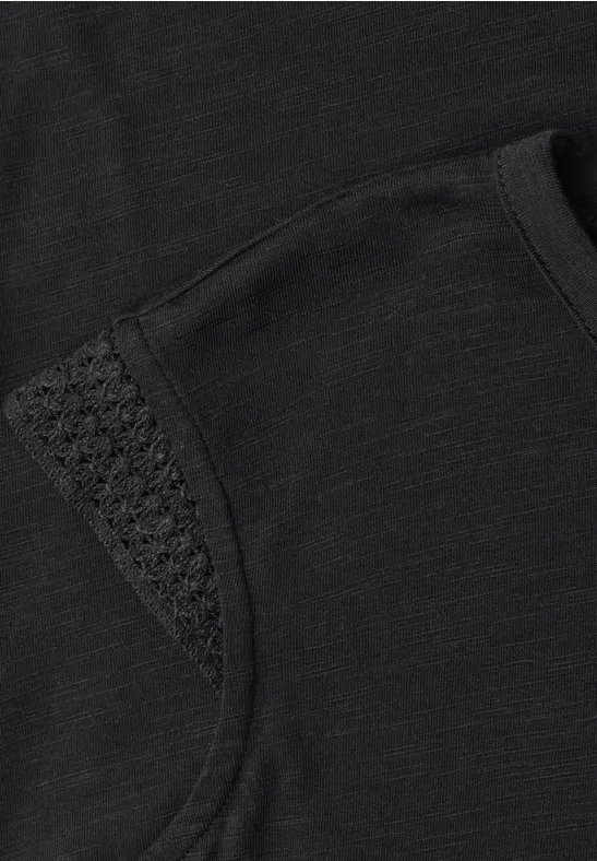 Zwart T-shirt met subtiel gehaakt detail op de schouder.