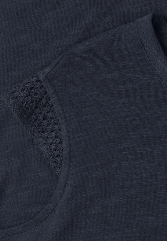 Donkerblauw shirt met fijn ajourdetail onder de mouw.