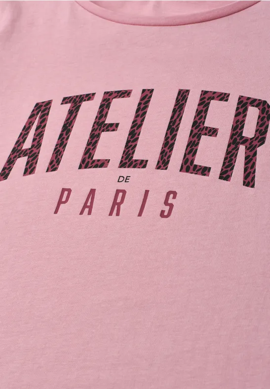 Een roze T-shirt met de zwarte tekst 'ATELIER de PARIS' op de voorkant.
