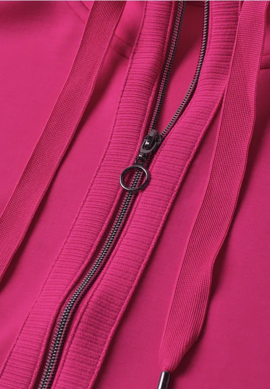 Nahaufnahme eines pinken Stoffs mit rundem Reißverschluss-Zipper und vertikalen Ziernähten.