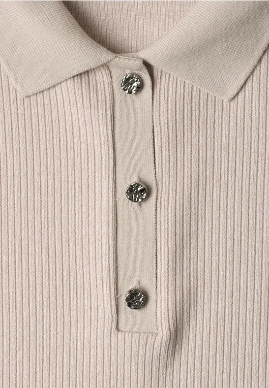 Beiges, fein geripptes Poloshirt mit Kragen und drei funkelnden Schmuckknöpfen.