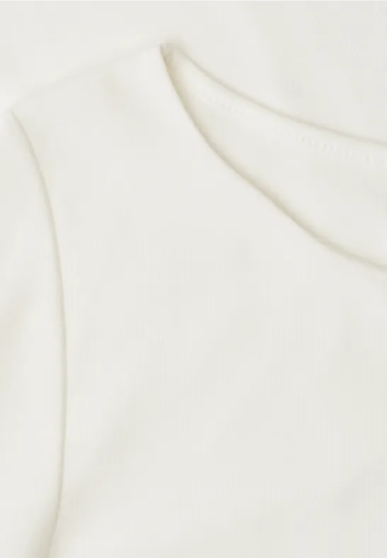 Close-up van een wit T-shirt met ronde hals op een lichte achtergrond.