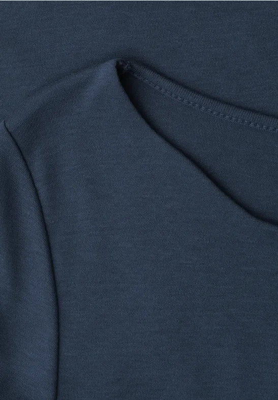 Gros plan d'un t-shirt bleu foncé avec une couture apparente