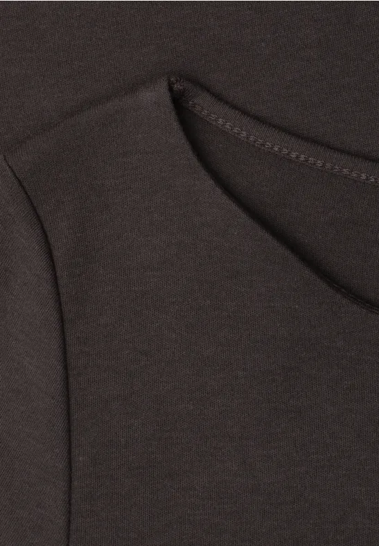 Gros plan d'un t-shirt noir avec encolure ronde et coutures apparentes.