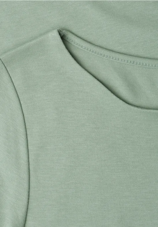 Nahaufnahme eines hellgrünen T-Shirts mit Rundhalsausschnitt und feiner Naht