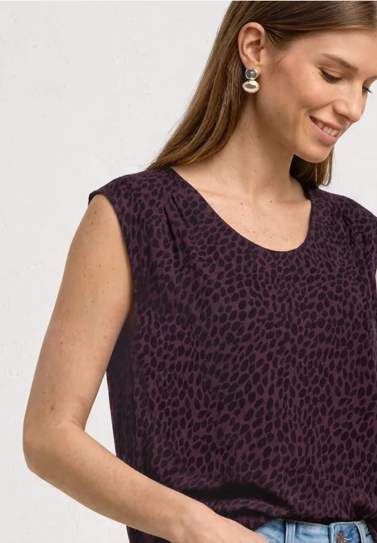 Ärmelloses Damen-Top in dunklem Violett mit dezentem Animal-Print, locker in Jeans gesteckt.